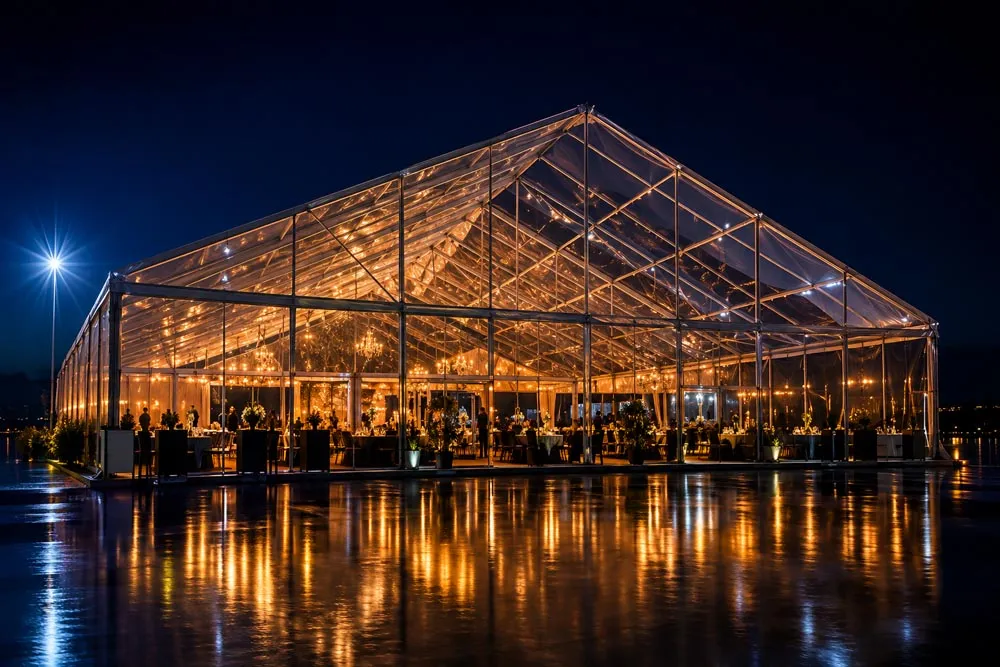 A clear-span event structure glowing at dusk
